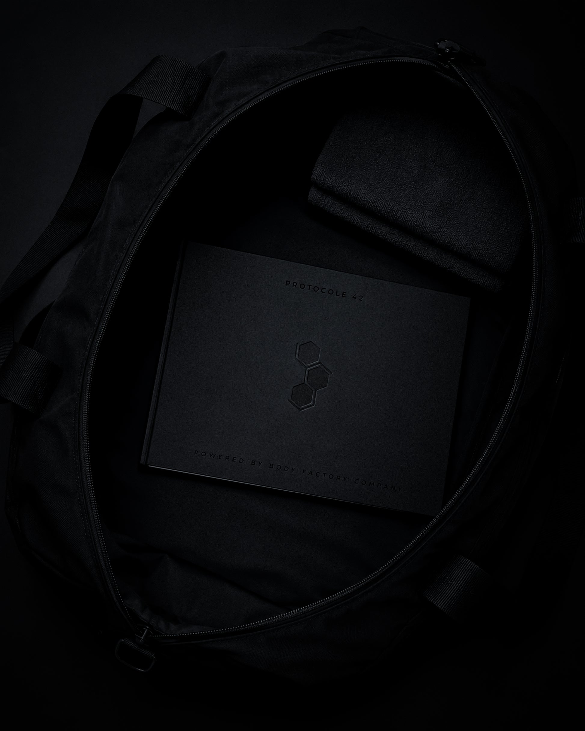 Carnet d’entraînement PROTOCOLE 42 rangé dans un sac de sport noir.